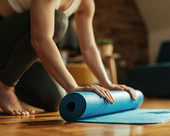 Woman rolling up fitness mat